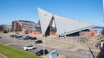 A parking lot with multiple cars and a building with a unique triangular roof.
