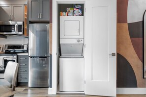 A compact kitchen with a microwave, refrigerator, and built-in oven. - 2BR Downtown Toronto | Steps to AGO & Queen West | Parking Available (Toronto)