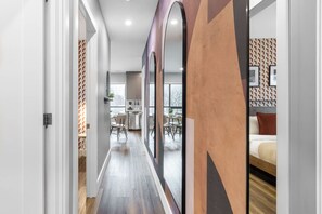 A modern interior with a hallway leading to a dining area and a bedroom.