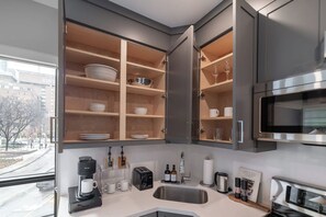 Eine moderne Küche mit eingebauten Schränken, einer Kaffeemaschine, einem Toaster und einer Mikrowelle.