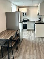 Cocina compacta con comedor, que incluye refrigerador, microondas, horno y pileta.