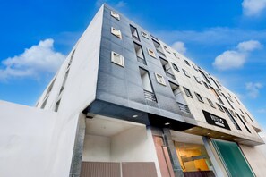 A modern hotel with a unique architectural design, featuring multiple balconies and a prominent entrance. - Hotel O Rangpuri Mahipalpur (New Delhi)