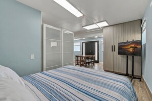 Ein Schlafzimmer mit Bett, Fernseher und Kleiderschrank.
