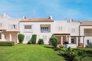 A two-story house with a well-maintained lawn, a garage, and a small garden area. - Casa da Galé | Pool & Terrace (Albufeira)