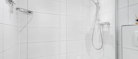 A modern shower area with a glass door, a handheld showerhead, and a wall-mounted towel rack.