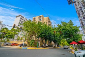 A street view with traffic lights, cars, and buildings. - Casa Celeste | Sunlit Tropical Stay in Condado (San Juan)