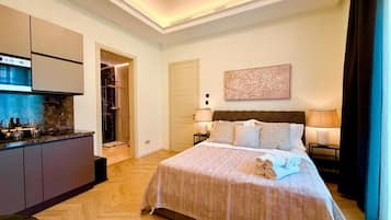 Quarto de hotel com cama, abajures, um quadro e vista para o exterior.