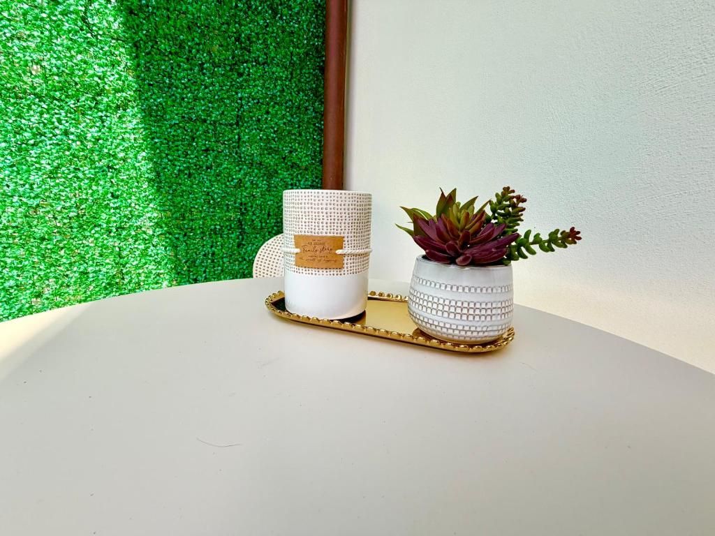 Due contenitori di ceramica bianca con bordo dorato su una superficie bianca, posizionati su un vassoio dorato.