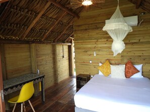 A wooden room with a bed, a desk, and a yellow chair.