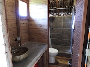 A wooden cabin bathroom with a toilet, a shower, and a wooden floor. - Ecohotel Payara Puerto Gaitán (Puerto Gaitán)