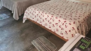 Habitación de hotel con dos camas, una pared de ladrillo y dos luces fijadas a la pared.