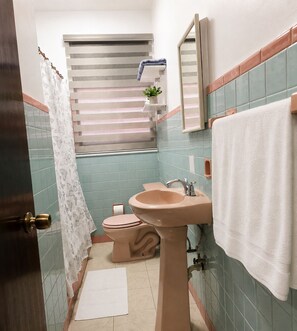 A bathroom with a toilet, sink, and shower curtain. - A Lounge Miramar 3 SJ 3BR  Near Condado Lagoon, OSJ & Distrito T-Mobile (Miramar)