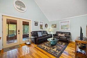 A spacious living room with a large window, a fireplace, and a cozy seating area. - Gorge-Us Getaway: A Cozy Retreat for Family and Friends (Zoe)