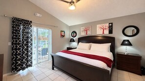 A bedroom with a bed, bedside tables, a ceiling fan, and artwork on the walls. - 4 BD/ 3 BA/ Rolling Hills Estates (7952 HE) (Kissimmee)