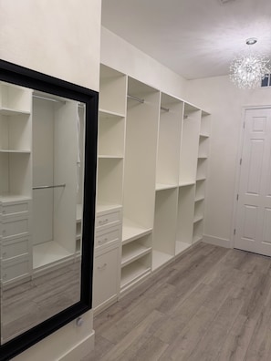 A walk-in closet with open shelving, a full-length mirror, and a door. - Relax, unwind and enjoy Lake Las Vegas! 
6 month bookings only (Henderson)