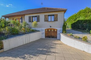 A two-story house with a tiled roof, a wooden door, and a paved driveway. - The House of Viennes (SAINT ANDRE LES VERGERS)