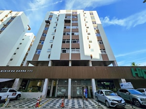 A multi-story building with a modern architectural design, featuring a prominent entrance with a metal gate and a patterned floor. - Barra - Salvador (Salvador)