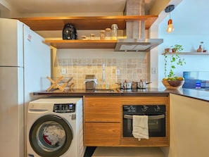 A compact kitchen with a washing machine, a dishwasher, a stove, and a sink. - Barra - Salvador (Salvador)