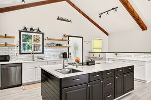 A modern kitchen with white cabinetry, a large island, and a black countertop.