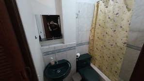 A small bathroom with a sink, toilet, and a mirror above the sink.