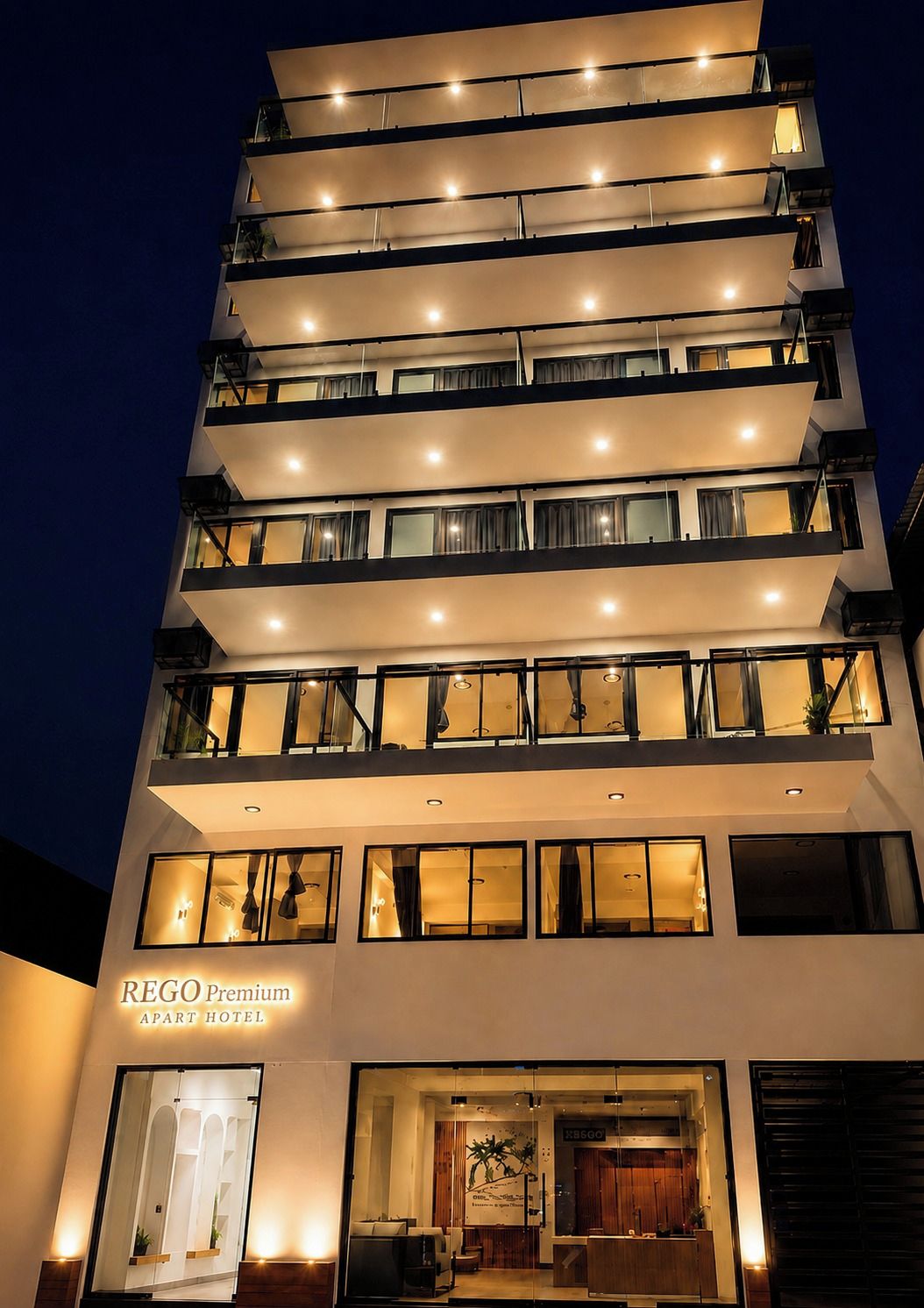 A multi-story hotel with a modern design, featuring balconies on each floor and a well-lit entrance.