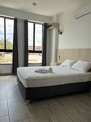 A hotel room with a large bed, a view of the cityscape, and a modern design. - Rego Premium Apart Hotel (Bagua Grande)