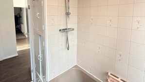 Ein Badezimmer mit einer Badewanne, einer Dusche und einem WC.