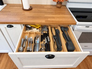 A kitchen drawer with utensils and a wooden cutting board on the countertop. - Bluebell Cottage, Walkable Fall City Stay w/ Hot Tub & Fenced Yard, Pets Welcome (Fall City)