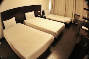 A hotel room with two single beds, a dark headboard, a nightstand, a chair, and a desk with a lamp. - LeMarly hotel (Beirut)