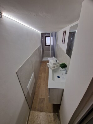 A narrow bathroom with a shower, a toilet, and a sink. - Cozy apartment in the heart of Trapani's historic center, near the harbor (Trapani)