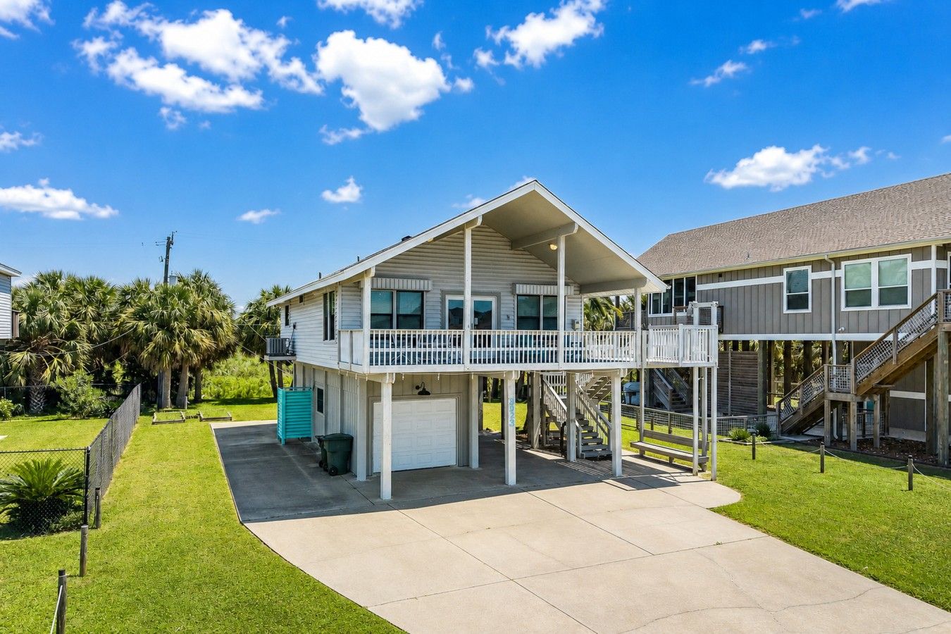 A two-story residential building with a balcony, a garage, and a staircase leading to an upper level.