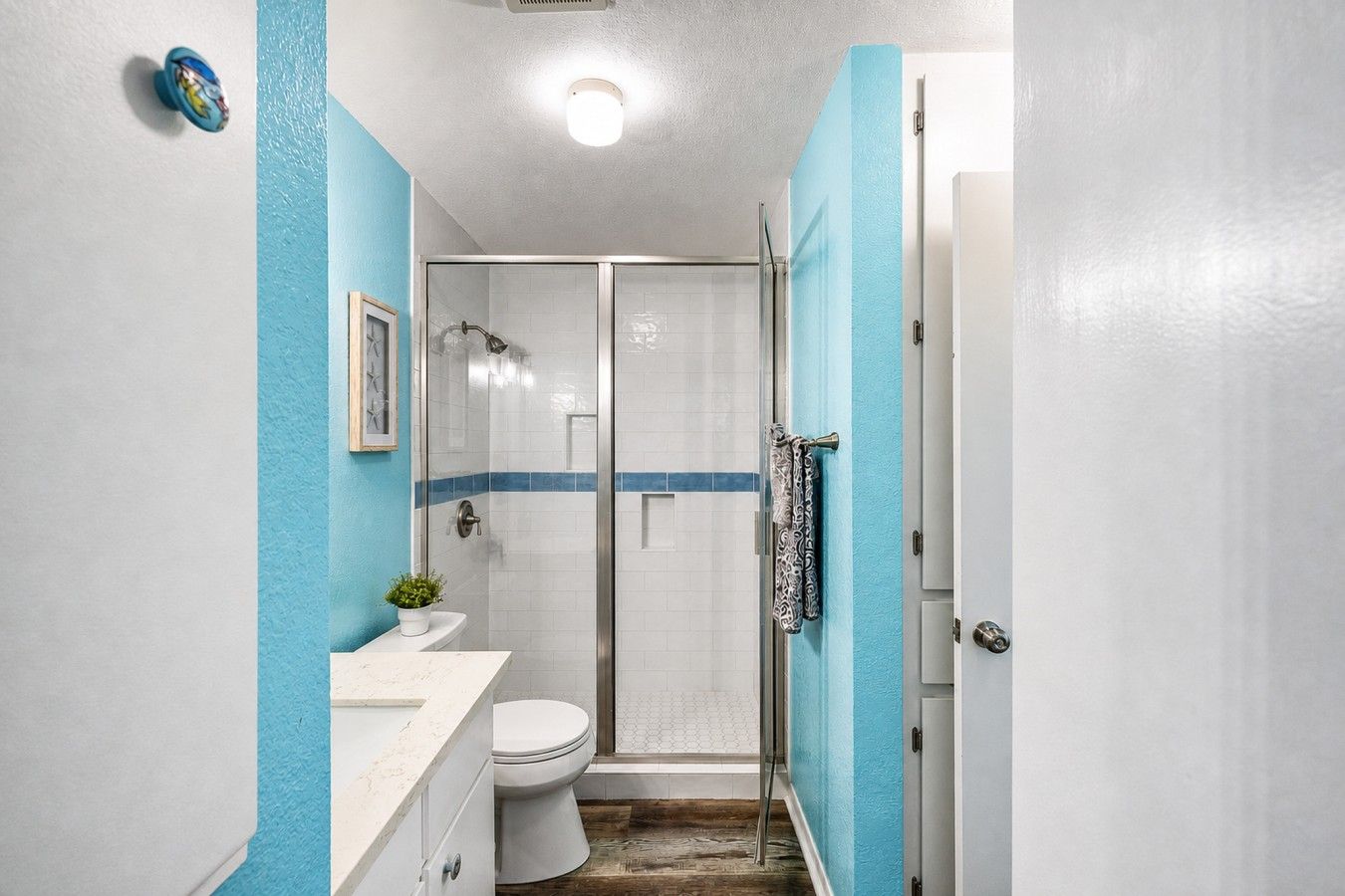 A bathroom with a shower, toilet, and sink.