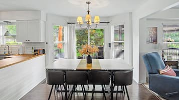 Un espace repas comprenant une table, des chaises et un lustre.
