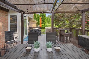 Terraza exterior con techo cubierto, mobiliario para exteriores y plantas en macetas.
