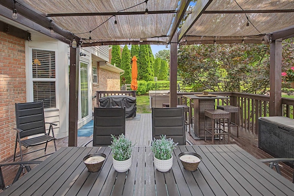An outdoor deck with a covered patio area, outdoor furniture, and potted plants. - Erlanger 4BR Hot Tub, Pool Table Sleeps 10 (Erlanger)