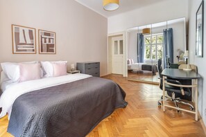A bedroom with a bed, bedside tables, a desk with a chair, a large mirror, and a sliding door leading to a balcony. - Blueground | New Town, view, nr Vltava River (PRG-125) (Prague)