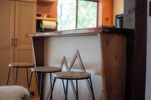 A kitchen area with a wooden counter and two stools. - Lakewood Escape - 3BR Retreat (South Lake Tahoe)