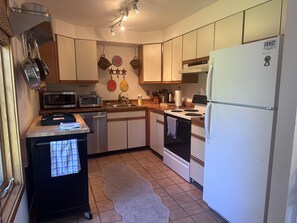 A kitchen with a microwave, toaster, sink, stove, and refrigerator.
