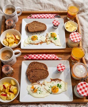 A breakfast tray with toast, eggs, fruit, and beverages.