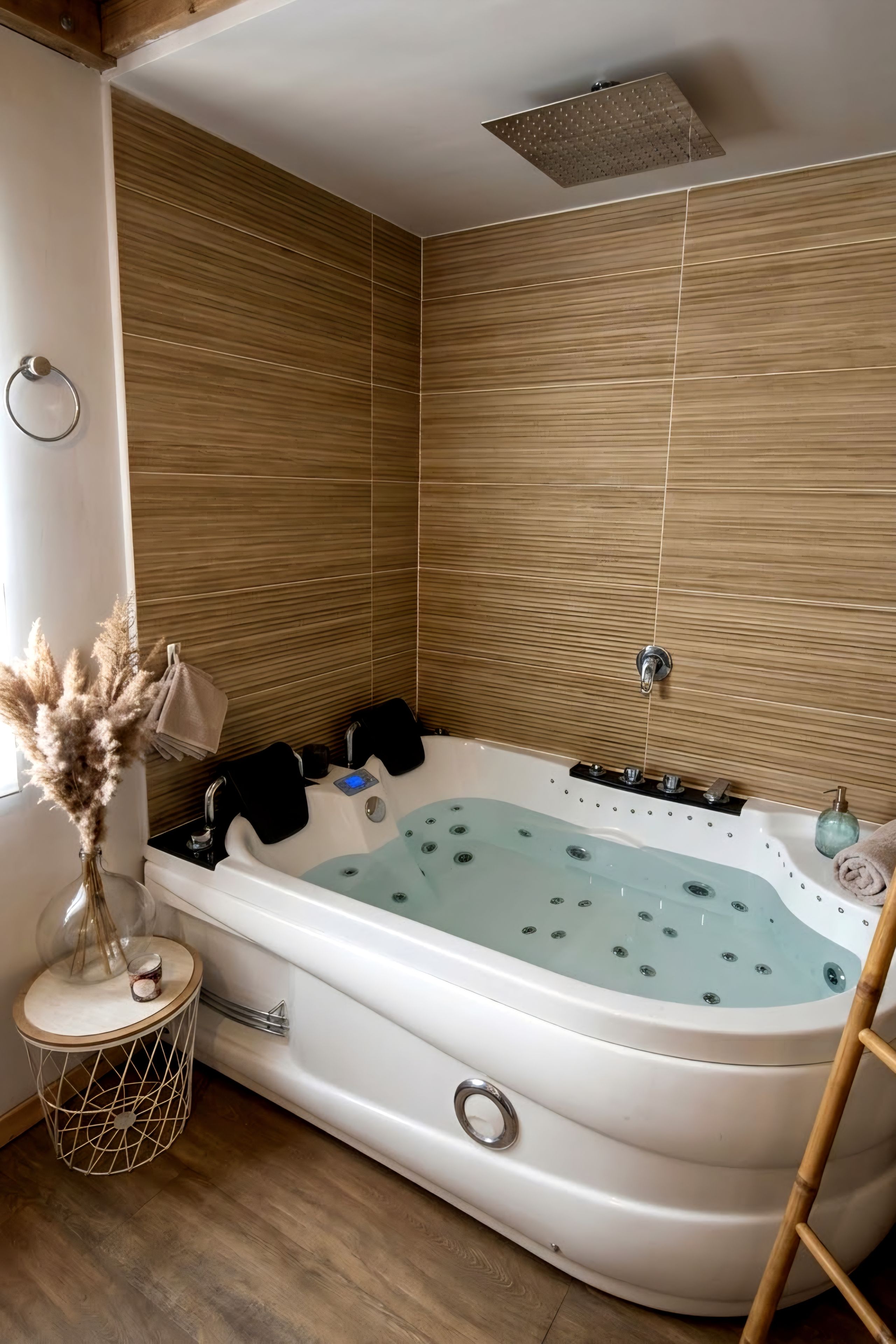 Une salle de bain moderne avec une baignoire sur pieds, des murs recouverts de panneaux en bois, une petite table ronde ornée d’un vase et une échelle en bois.