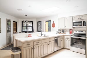 A modern kitchen with a central island, stainless steel appliances, and a dishwasher.