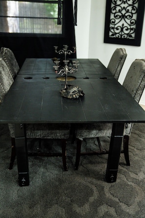 A rectangular dining table with a dark finish, surrounded by six upholstered chairs with a textured fabric.