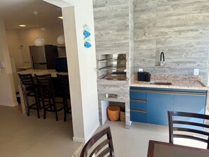 Eine moderne Küche mit einer Granit Arbeitsplatte, blauen Schränken und einem Edelstahlspülbecken.