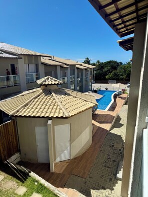 A residential building with a swimming pool, a covered patio, and a fenced yard. - 2-bedroom village house in Imbassai Beach, Bahia, 5 minutes from the beach, close to the sea! (Mata de São João)