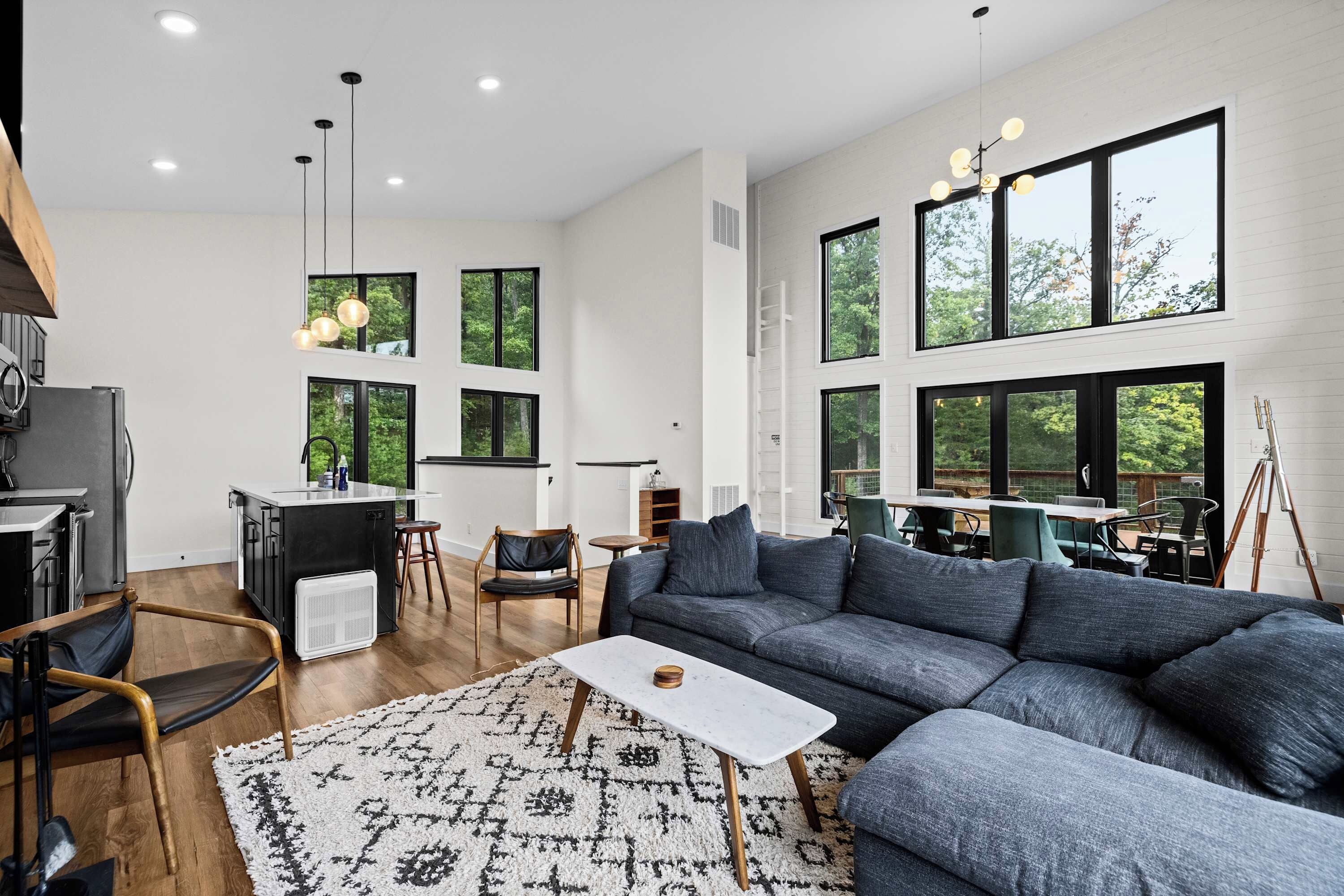 A modern living room with a sectional sofa, a small coffee table, and a dining area with a table and chairs.