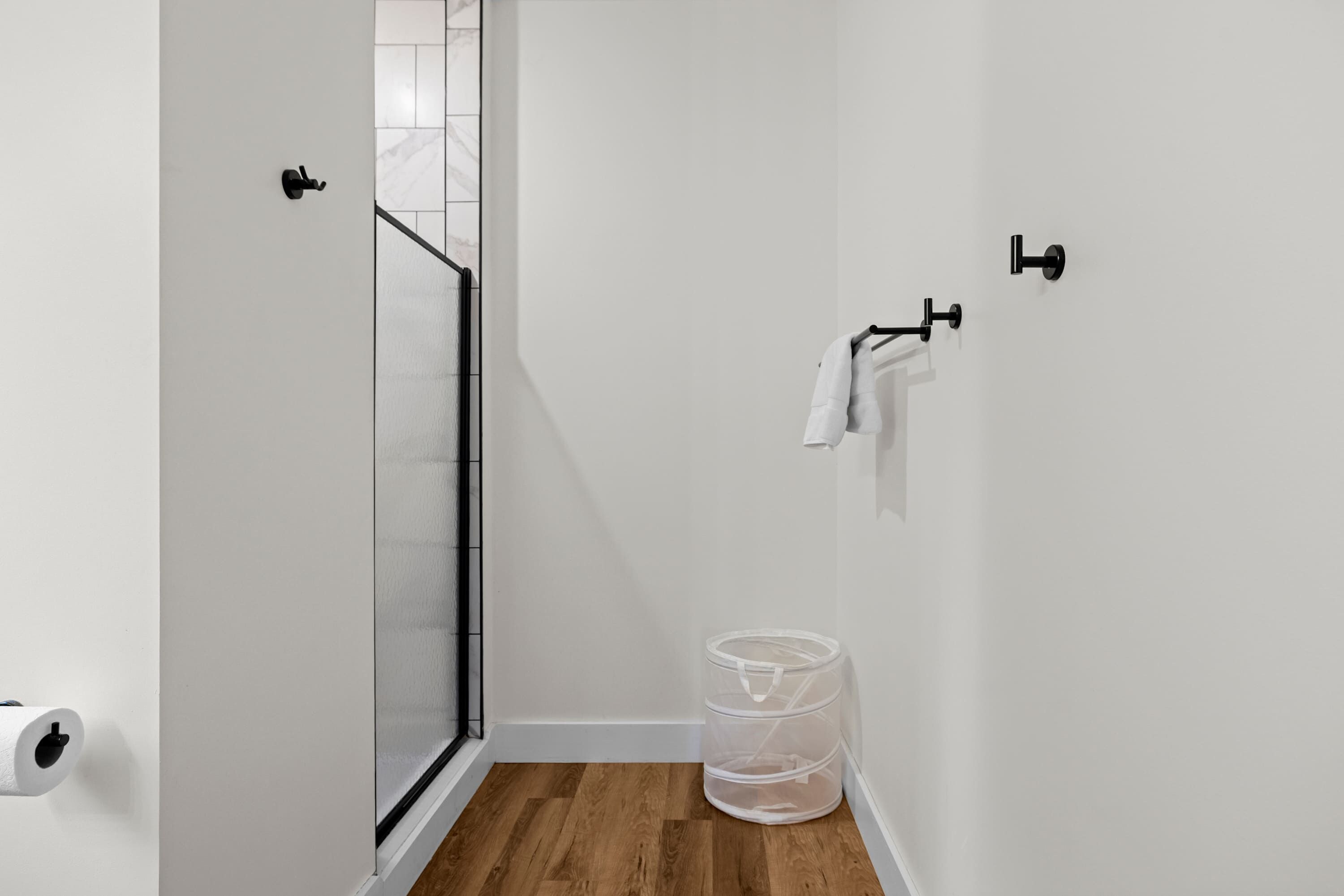 Un baño pequeño y moderno con ducha, inodoro y barra para toallas.