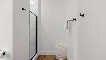 Un baño pequeño y moderno con ducha, inodoro y barra para toallas.