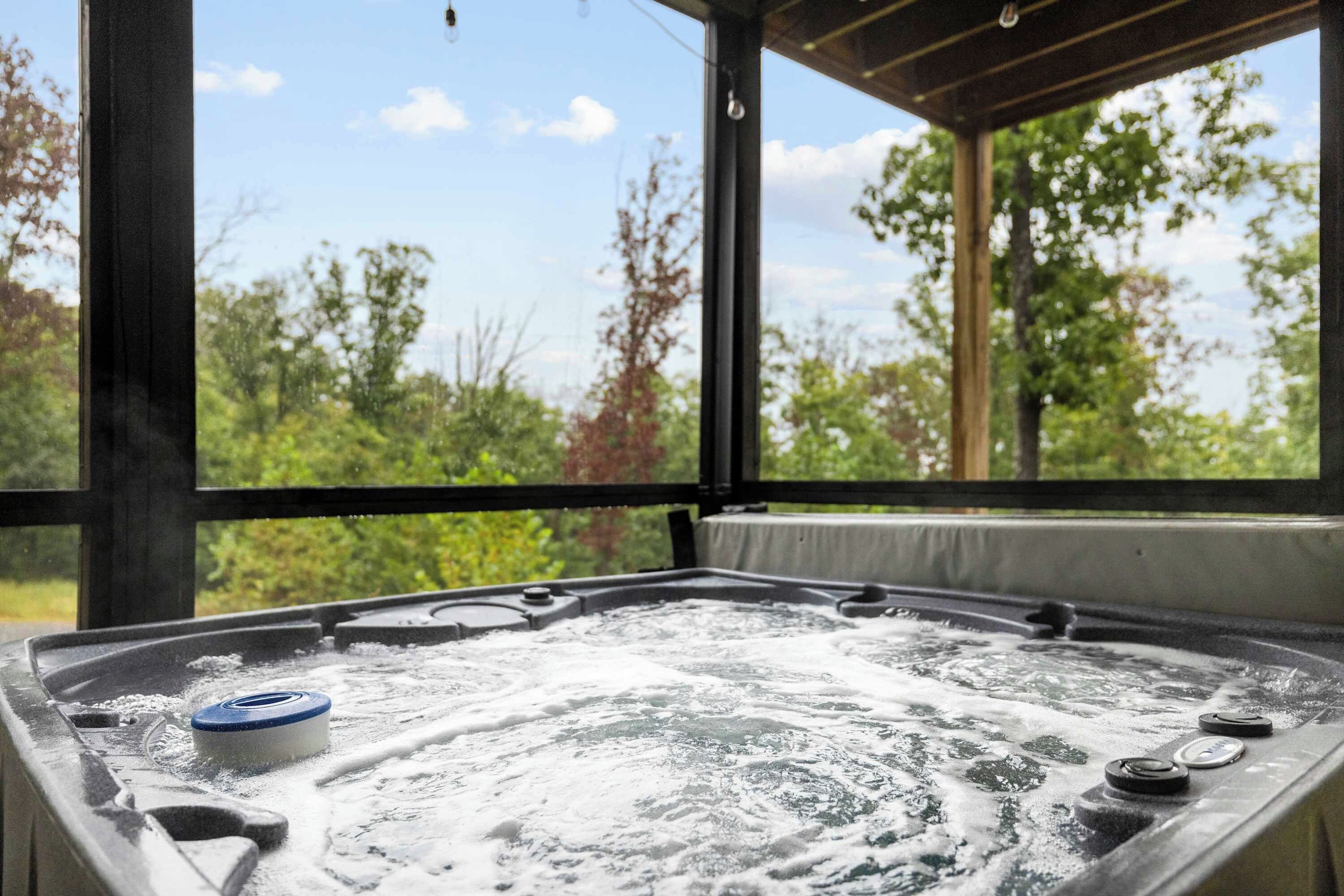 A hot tub with a view of trees and sky through a covered area.