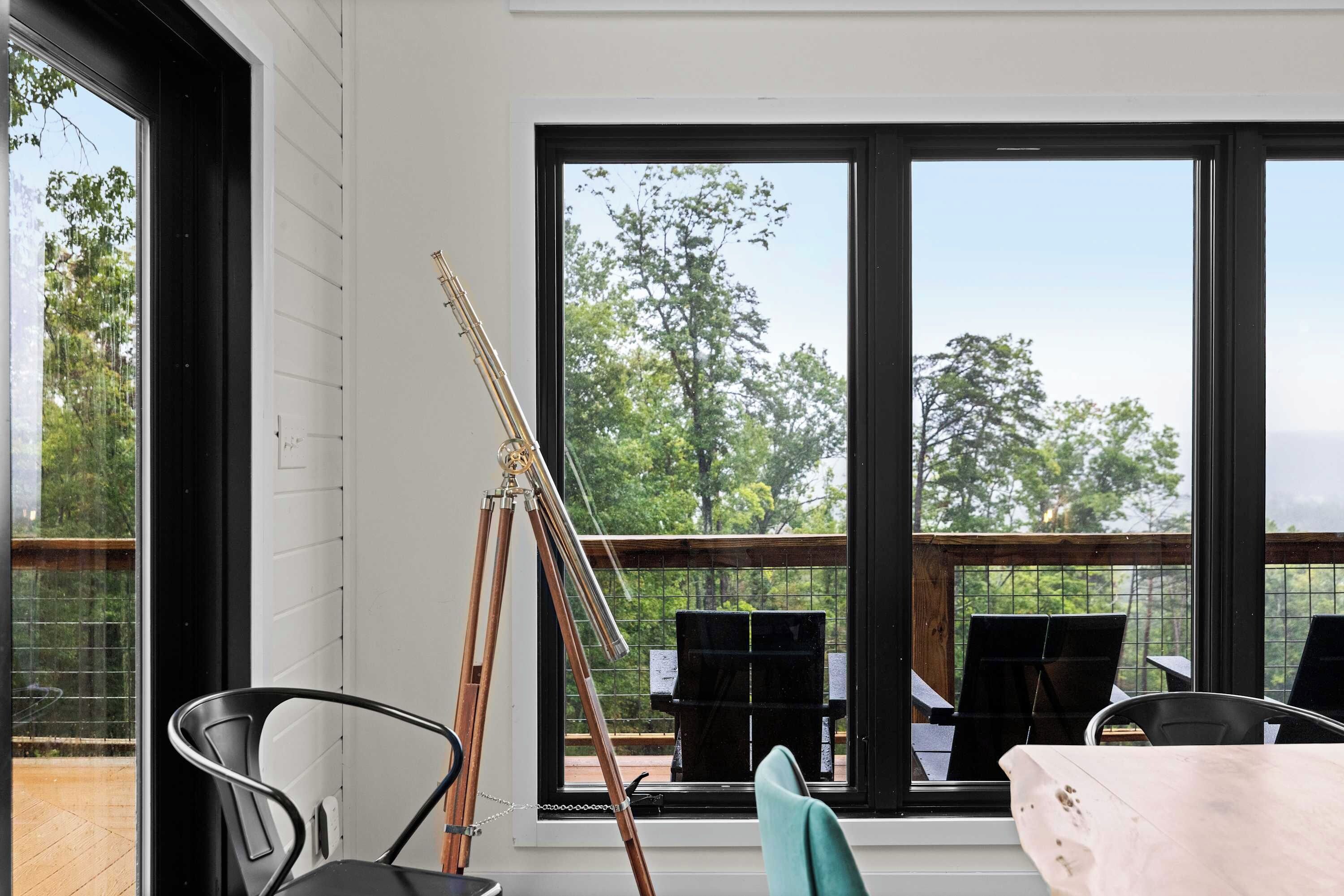 Ein Zimmer mit einem großen Fenster, einem Stativ und einem Stuhl.