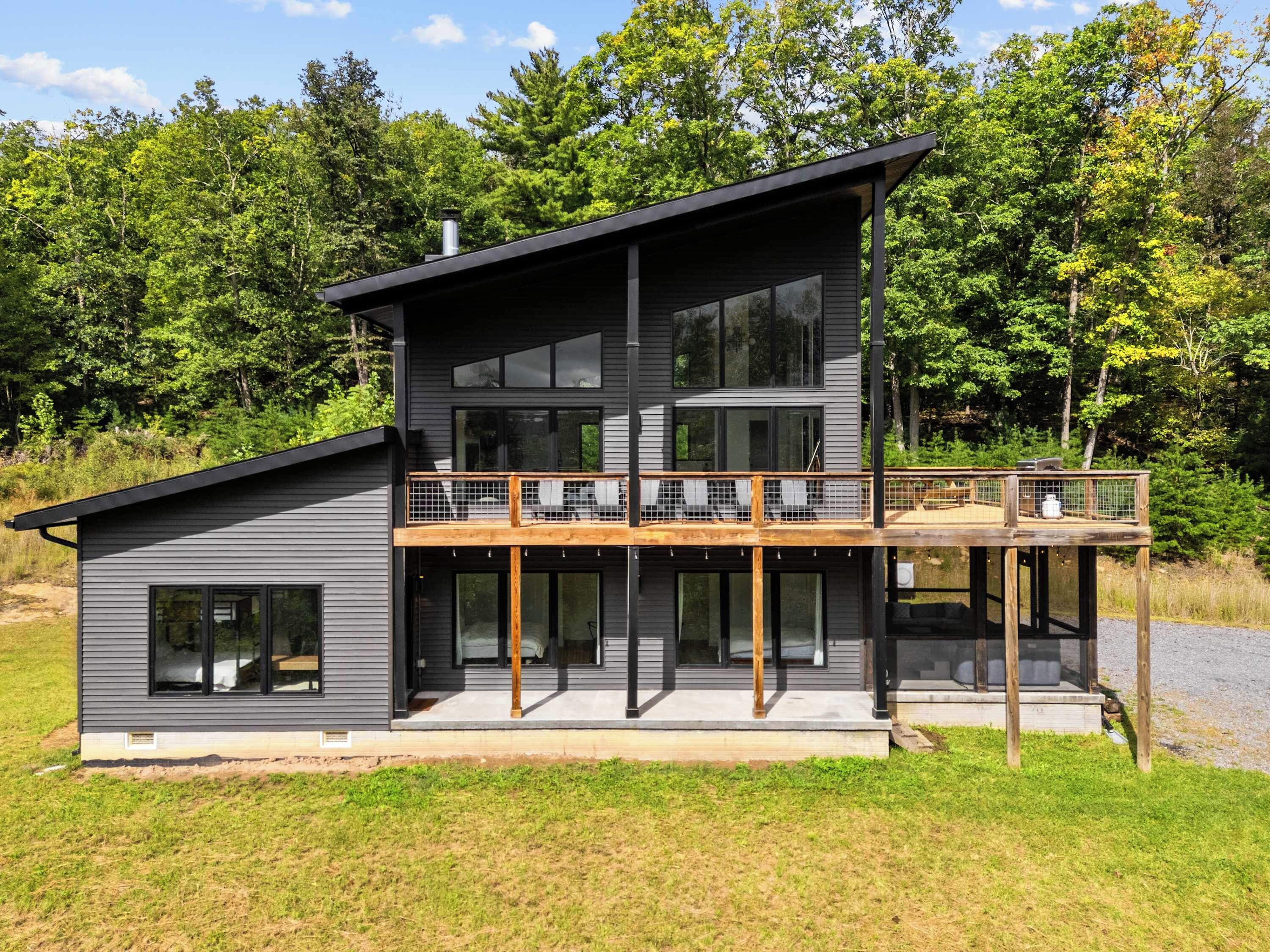 A modern two-story house with a balcony and large windows.